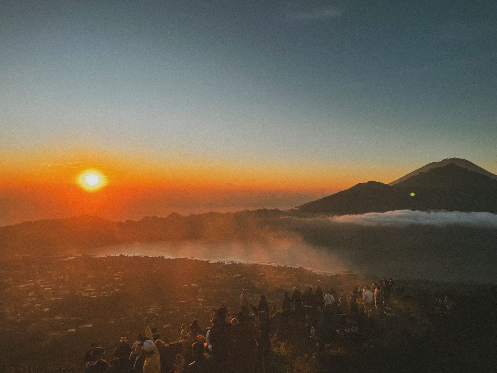 People on a summit watching the sunrise above the clouds