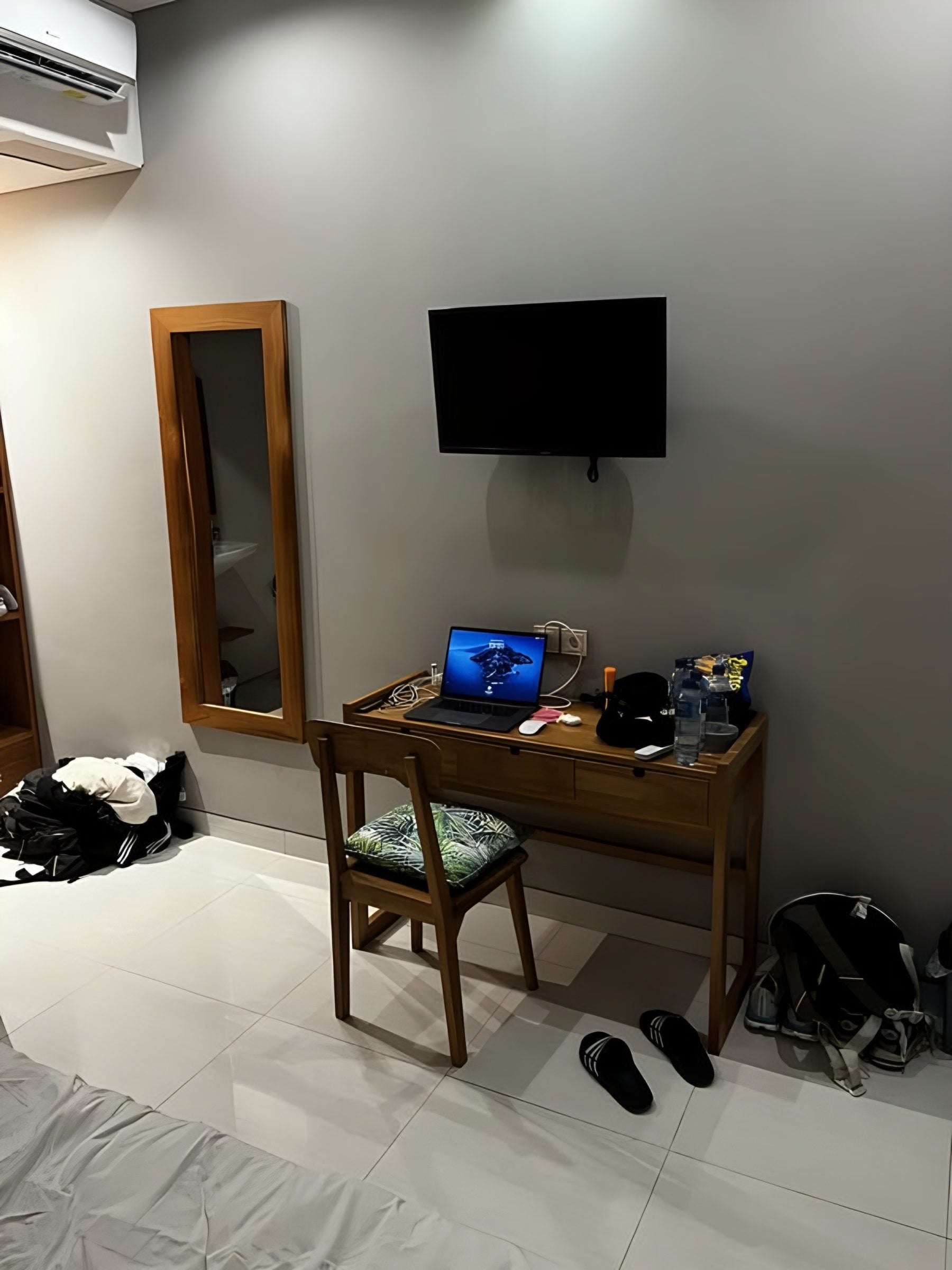 Workspace in a room in Bali: desk with laptop, mirror and TV