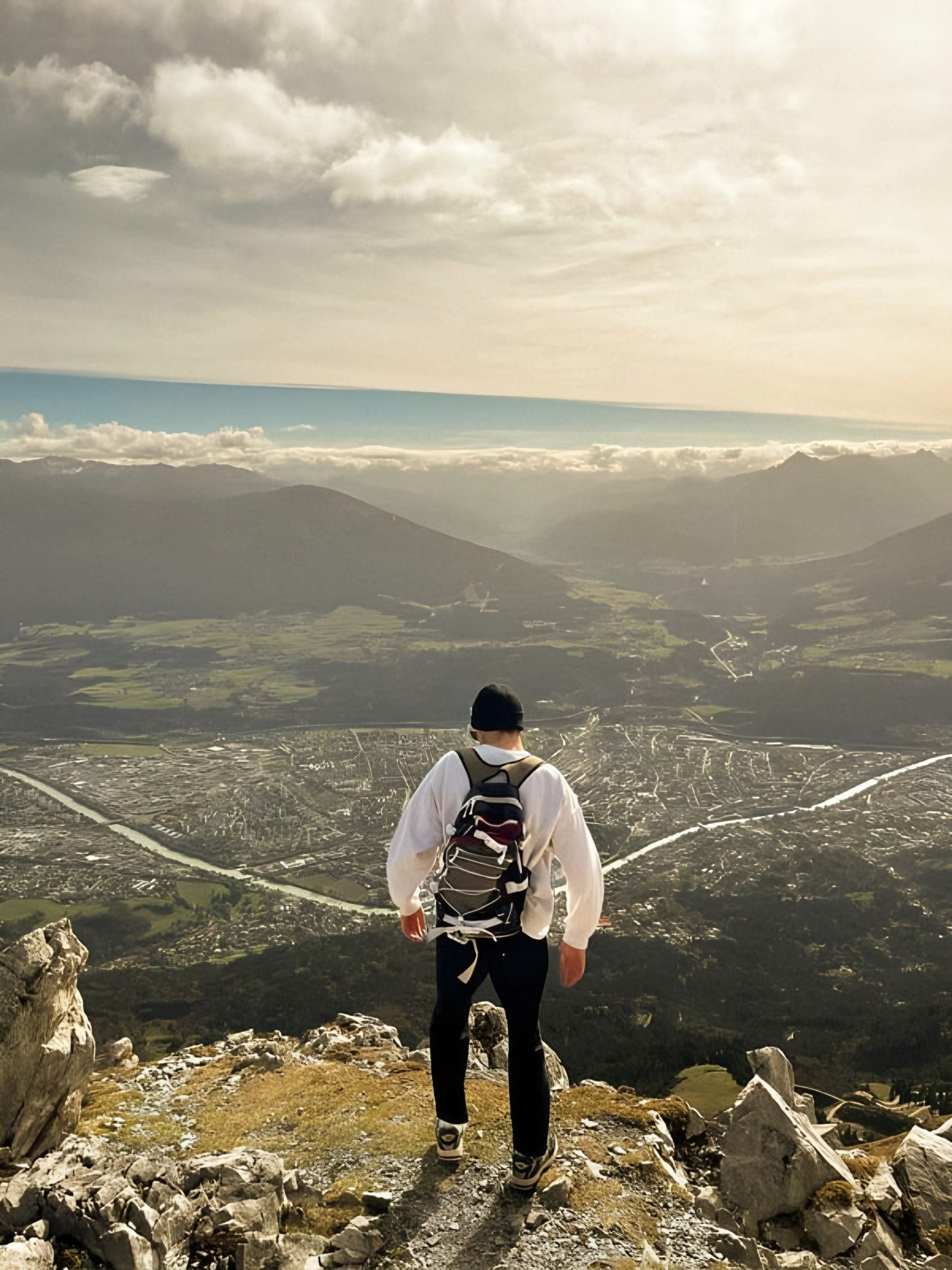 Erik with a backpack on a summit, looking over the Inn valley near Innsbruck