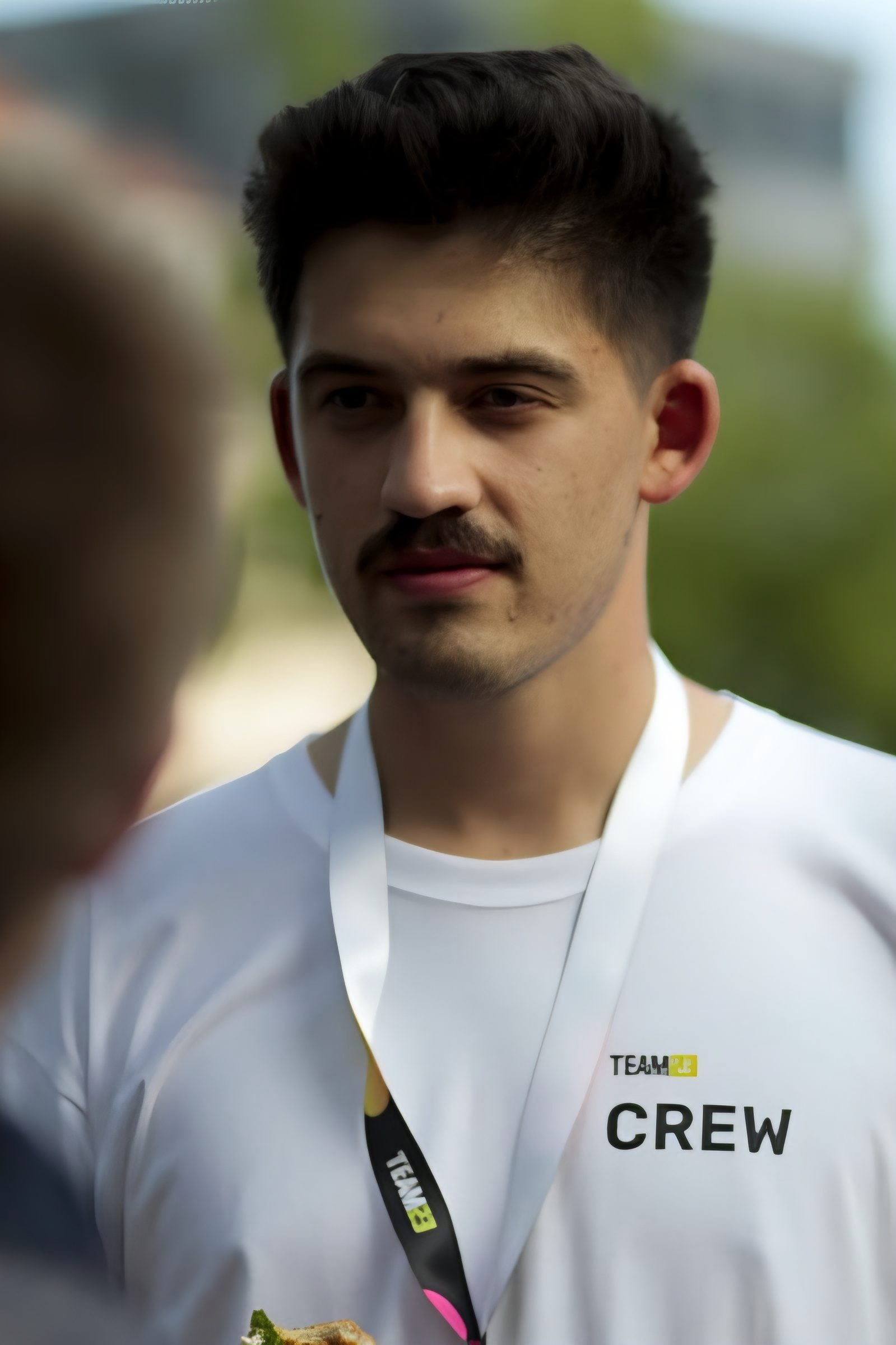 Erik in a white TEAM23 crew shirt with a lanyard